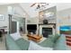 Cozy living room featuring a fireplace, a comfortable green sofa, and access to the entryway at 5219 Guava Ter, Port Charlotte, FL 33981