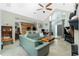 Spacious living room with a comfortable green sofa, tile flooring, and an open concept design at 5219 Guava Ter, Port Charlotte, FL 33981