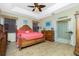 Main bedroom with tropical decor, a four-poster bed, wood floors, and ensuite bath at 5219 Guava Ter, Port Charlotte, FL 33981