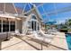 Relaxing poolside featuring lounge chairs, dining set, umbrella, and easy access to the home's interior at 5219 Guava Ter, Port Charlotte, FL 33981