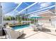 Inviting screened-in pool with dining set, lounge chair, and sun umbrella for a relaxing outdoor experience at 5219 Guava Ter, Port Charlotte, FL 33981
