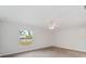 Bright bedroom with a ceiling fan, a large window, and neutral-toned tile flooring at 5353 Kaspar St, Port Charlotte, FL 33981