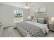 Bright bedroom featuring a queen size bed and a view of the front yard at 5353 Kaspar St, Port Charlotte, FL 33981