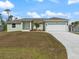 Charming single-story home showcasing a well-maintained lawn, a paved driveway, and a two-car garage at 5353 Kaspar St, Port Charlotte, FL 33981