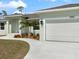 A tidy two-car garage with an extended driveway and vibrant landscaping that accents the curb appeal at 5353 Kaspar St, Port Charlotte, FL 33981