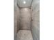 Walk-in shower featuring gray tile, mosaic flooring, and a modern shower head at 5353 Kaspar St, Port Charlotte, FL 33981