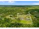 Beautiful aerial view of a sprawling home with a pool and guesthouse surrounded by lush greenery and defined property lines at 5600 Blackjack S Ct, Punta Gorda, FL 33982