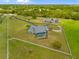 Aerial view of a house with a screened-in pool and a large yard surrounded by a white fence and mature trees at 5600 Blackjack S Ct, Punta Gorda, FL 33982