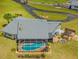 Aerial view of a home with a screened pool, a deck with a pergola, a chimney, and a circular driveway at 5600 Blackjack S Ct, Punta Gorda, FL 33982
