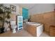 Charming bathroom features tiled floors and walls, a tub, toilet, and colorful cabinet at 5600 Blackjack S Ct, Punta Gorda, FL 33982