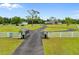 Long gated driveway leading to a beautiful home with a large front yard and lush landscaping, offering privacy at 5600 Blackjack S Ct, Punta Gorda, FL 33982