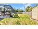 Wide-angle view of a spacious backyard with pool enclosure, lush lawn, and shed at 566 Reading Nw St, Port Charlotte, FL 33952