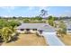 Well-maintained single-story home with manicured lawn and mature trees in a serene neighborhood at 566 Reading Nw St, Port Charlotte, FL 33952