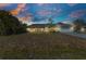 A single-story home sits nestled in a neighborhood with a large well-manicured front lawn at 566 Reading Nw St, Port Charlotte, FL 33952