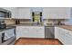 Kitchen with stainless steel appliances, bright white cabinets, and wood-look flooring at 566 Reading Nw St, Port Charlotte, FL 33952