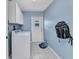 Practical laundry room features washer, dryer, storage cabinets, and easy access to the backyard at 566 Reading Nw St, Port Charlotte, FL 33952