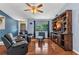 Relaxing living room featuring a custom entertainment center, a ceiling fan, and wood-look flooring at 566 Reading Nw St, Port Charlotte, FL 33952