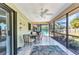 Covered screened patio includes outdoor dining area, ceiling fan, and pleasant views of the backyard and pool at 566 Reading Nw St, Port Charlotte, FL 33952