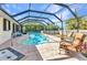 Refreshing swimming pool in screened enclosure, complete with lounge chairs and a relaxing backyard setting at 566 Reading Nw St, Port Charlotte, FL 33952