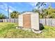 Exterior view of backyard storage shed with a well-kept lawn and privacy fence at 566 Reading Nw St, Port Charlotte, FL 33952