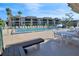 Relaxing pool area with ample seating, palm trees, and building in the background at 601 Shreve St # 64C, Punta Gorda, FL 33950