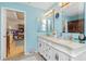 Bright bathroom featuring dual vanity sinks, tile floors, and natural light at 6103 Fabian Rd, North Port, FL 34287