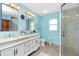 Bright bathroom featuring dual vanity sinks, granite countertops, and tiled shower at 6103 Fabian Rd, North Port, FL 34287