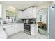 Well-equipped kitchen with white cabinetry, stainless steel appliances, and an open view into the dining area, perfect for entertaining at 6103 Fabian Rd, North Port, FL 34287