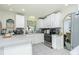 Efficient kitchen layout featuring white cabinets, modern appliances, and an open doorway leading to the dining area, enhancing flow at 6103 Fabian Rd, North Port, FL 34287