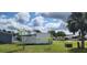 Mobile home in a landscaped neighborhood, with green lawns and mature shade trees at 6843 Amoko Ct, North Port, FL 34287