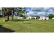 Mobile home in a landscaped neighborhood, with green lawns and mature shade trees at 6843 Amoko Ct, North Port, FL 34287