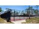 Well-maintained tennis court with a secure black fence, providing a great space for sports and recreation at 6843 Amoko Ct, North Port, FL 34287