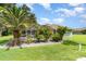 Expansive backyard featuring a screened pool area, palm trees, and meticulously maintained landscaping at 7101 Dogwood Ct, North Port, FL 34287