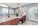 Bathroom featuring double sinks, a large mirror, and a shower with glass block window for natural light at 7101 Dogwood Ct, North Port, FL 34287