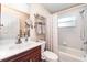 Bathroom featuring a single sink vanity, mirrored cabinet, toilet, and tub-shower with curtain at 7101 Dogwood Ct, North Port, FL 34287