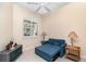Bright bedroom with a convertible blue sofa bed, side tables with lamps, and a window with shutters at 7101 Dogwood Ct, North Port, FL 34287