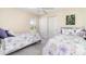 Bedroom featuring two twin beds, white doors to the closet, and a window with plantation shutters at 7101 Dogwood Ct, North Port, FL 34287