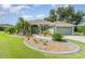 Charming single-story home with lush landscaping, palm trees, and a well-maintained lawn under a partly cloudy sky at 7101 Dogwood Ct, North Port, FL 34287