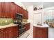 Well-equipped kitchen with wood cabinetry, stainless steel appliances, and a breakfast bar open to the dining area at 7101 Dogwood Ct, North Port, FL 34287