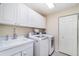 Laundry room with white cabinetry, a sink, and a washer and dryer, all in a clean and organized space at 7101 Dogwood Ct, North Port, FL 34287