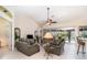 Comfortable living room with tile floors, ceiling fan, and sliding glass doors leading to an outdoor pool area at 7101 Dogwood Ct, North Port, FL 34287