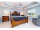 Comfortable bedroom with a decorative tray ceiling, ceiling fan, wooden bed frame and matching nightstands at 7101 Dogwood Ct, North Port, FL 34287