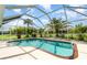 Lovely swimming pool surrounded by lush tropical landscaping, enclosed within a screened lanai at 7101 Dogwood Ct, North Port, FL 34287