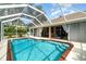 Sparkling screened-in pool with brick trim, set amidst the home's serene outdoor living space at 7101 Dogwood Ct, North Port, FL 34287