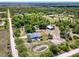 Expansive aerial view of the property showing the house, pond, surrounding land and wooded areas at 7274 Alan Blvd, Punta Gorda, FL 33982