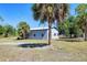 Exterior view of a barn surrounded by a large grassy yard, palm trees, and smaller trees at 7274 Alan Blvd, Punta Gorda, FL 33982