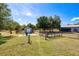 Wide view of the fenced-in backyard with a storage shed, barn, and luscious green space at 7274 Alan Blvd, Punta Gorda, FL 33982