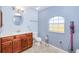 Bright bathroom features tile floors, vanity with custom mirror and countertop, toilet and a large window at 7274 Alan Blvd, Punta Gorda, FL 33982