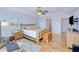 Spacious main bedroom with wood floors, ceiling fan, wooden bed frame and en suite bathroom at 7274 Alan Blvd, Punta Gorda, FL 33982