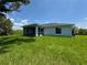 Backyard view with a well-maintained lawn, covered patio, and rear exterior windows at 8667 Lisa Blvd, North Port, FL 34288